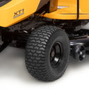 Close-up of a yellow lawn mower with 'XT1' branding on a white background