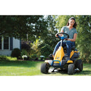 Woman operating a yellow riding lawn mower in a garden.